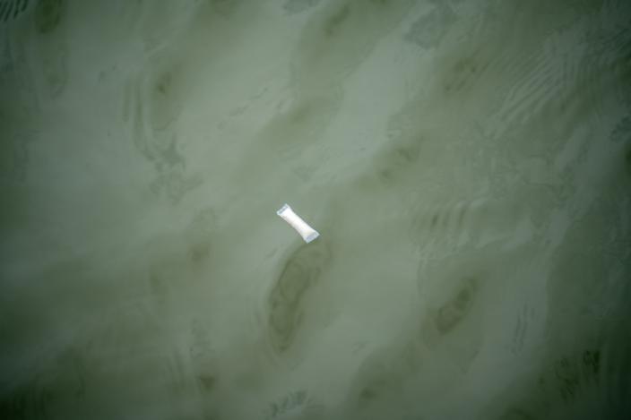 Nikotiinipussi kelluu veden pinnalla. (Kuva: Kiia Palo / Pidä Saaristo Siistinä ry)