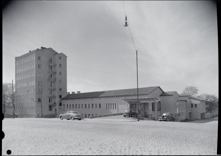Vanha valokuva sairaalarakennuksesta, vasemmalla monikerroksinen tornirakennus, jonka vieressä matala sairaalasiipi ja sisäänkäynti. (Kuva: Heikki Havas)