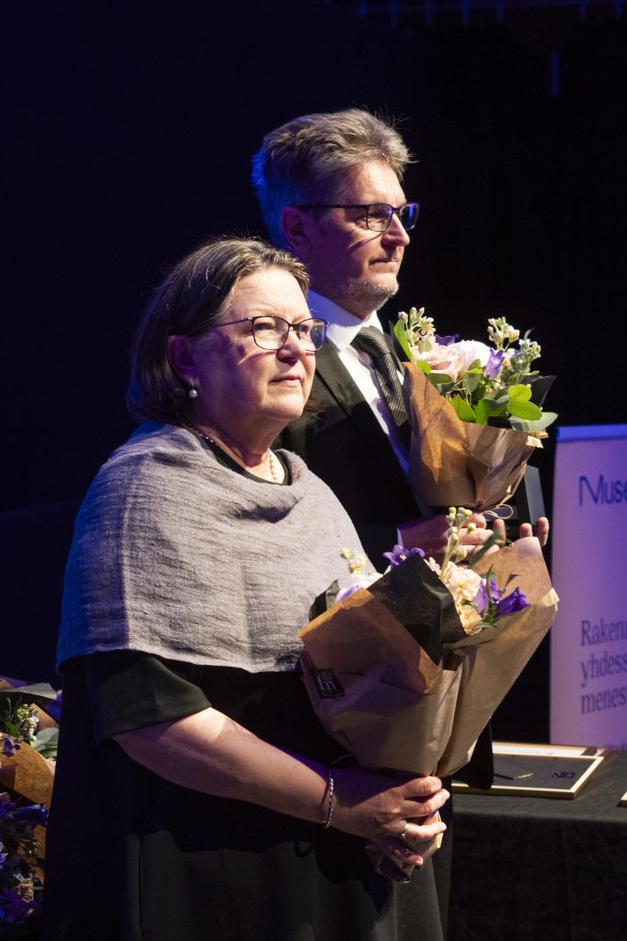 Kaksi henkilöä kukkakimput käsissään. (Kuva: Veera Korhonen, Suomen Museoliitto)