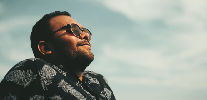 Mies nautiskelee auringosta kesäpäivänä.