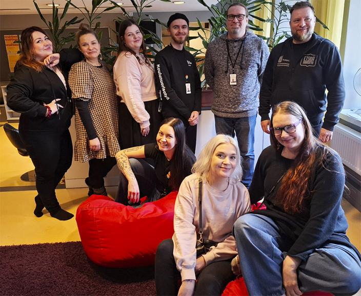 Iloisia ihmisiä poseeraa ryhmäkuvassa. (Kuva: Maria Vakkamaa)