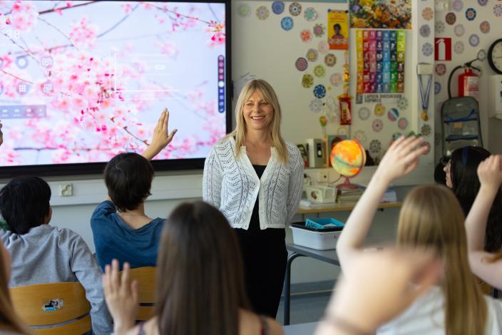 Yläkoulun opettaja ja viittaavia oppilaita oppitunnilla. (Kuva: Jussi Vierimaa)