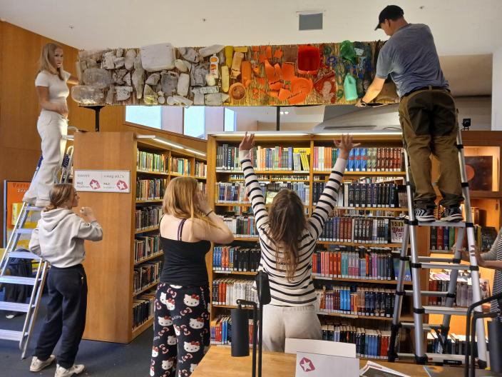 Nuoret ripustavat ilmastoprojektitöitään pääkirjastossa. (Kuva: Petra Svahn)