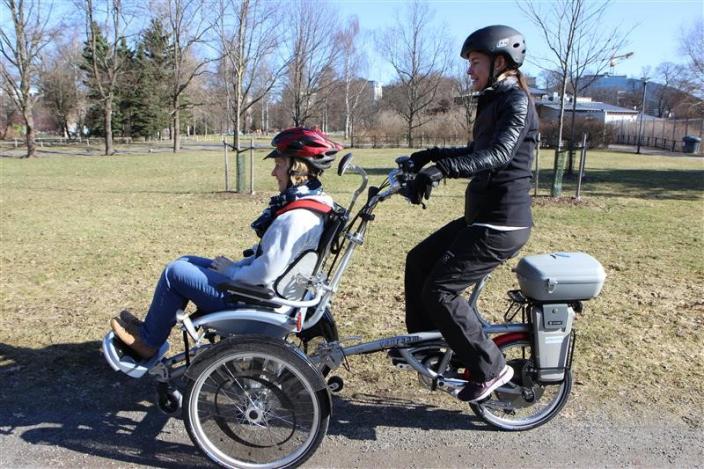 A woman sits on the front of a bicycle while another person pedals the bike. (Picture: Johanna Friman)