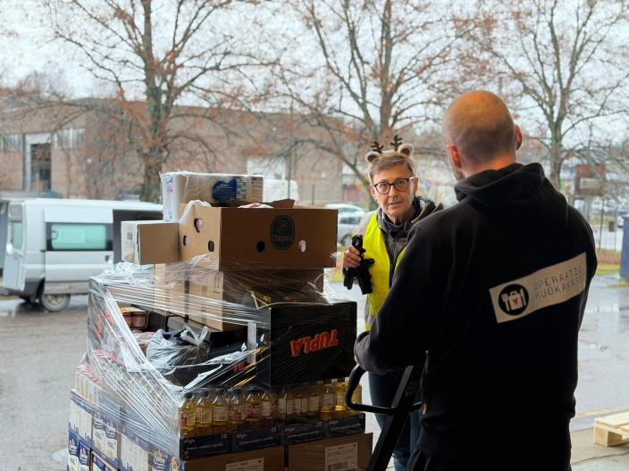 Operaatio Ruokakassin työntekijät kuljettavat ruokalavaa pumppukärryillä. (Foto: Operaatio Ruokakassi)