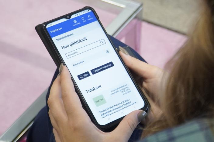 Puhelimen ruudulla näkymä Päätökset-palvelun hakukentästä otsikolla "hae päätöksiä" ja hakusanalla "kauppatori".