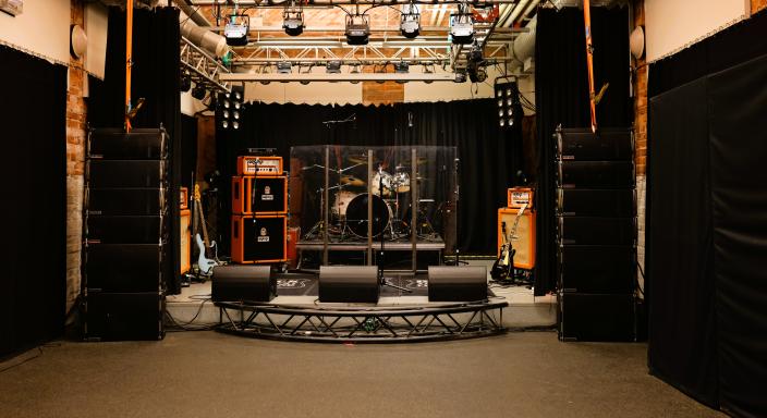Matalalla lavalla on rummut, kitaroita, vahvistimia ja kaiuttimia. (Kuva: Kari Brandstaka)