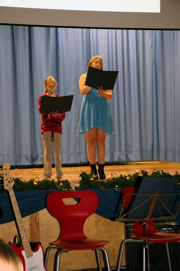 Kaksi oppilasta juontaa juhlaa lavalla.