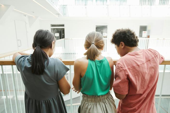 Tre ungdomar fotograferade bakifrån. (Foto: Pexells kuvapankki Norma Mortenson)