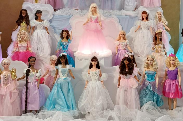 Rivissä noin 20 barbie-nukkea röyhelöisissä mekoissa.