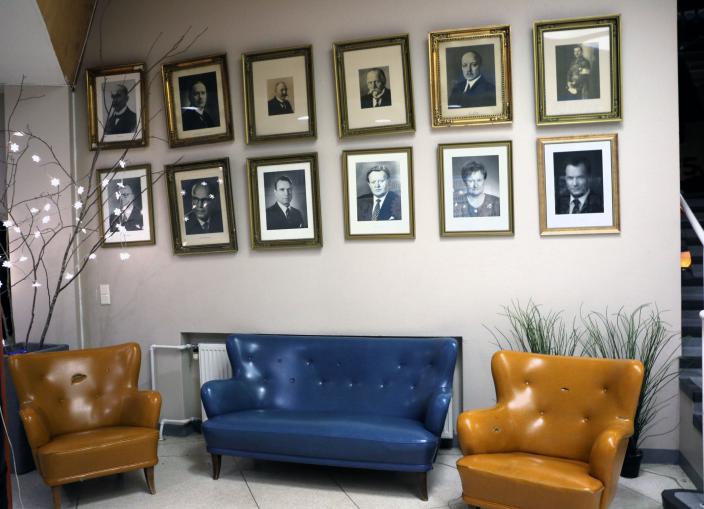 Suomen presidenttien valokuvat seinällä ja vanhat vintagesohvat. 