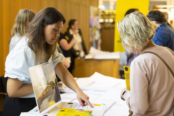 Henkilö osoittaa paperia toiselle henkilölle. (Kuva: Jussi Virkkumaa)