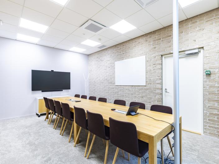 Monitoimitalo Riimin neuvotteluhuone, jossa pitkä pöytä ja näyttö. (Kuva: Heikki Räisänen)