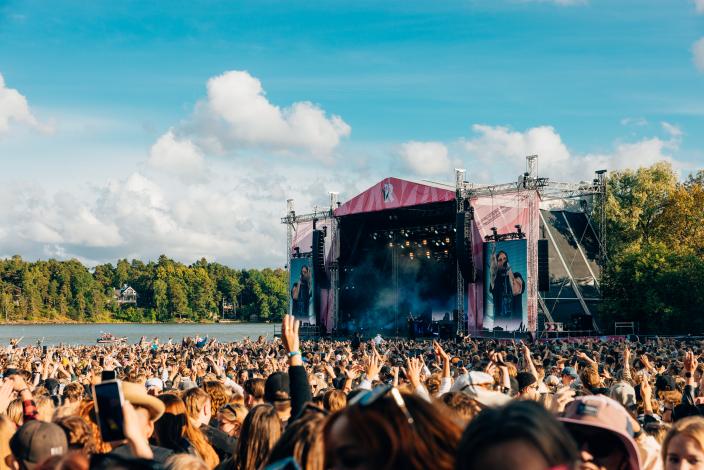 Kuvassa on Ruisrockin rantalava, jossa on menossa konsertti. Konserttia seuraa valtava yleisö.