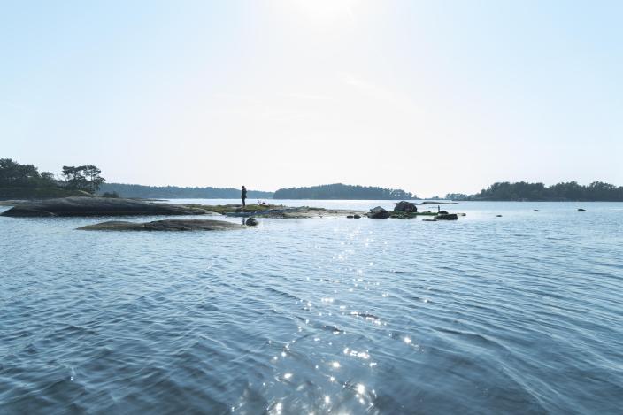 A maritime and sunny picture, where a person is standing on a small island surrounded by the sea. (Picture: Visit Turku Archipelago)