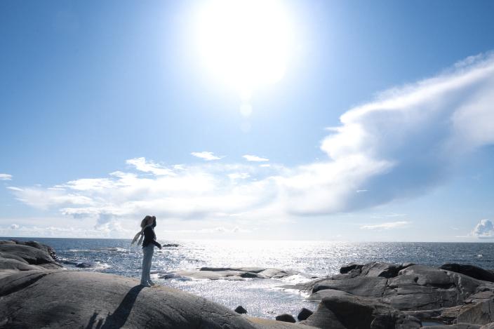 Henkilö seisoo kalliolla meren äärellä Turun saaristossa. (Picture: Visit Turku Archipelago)