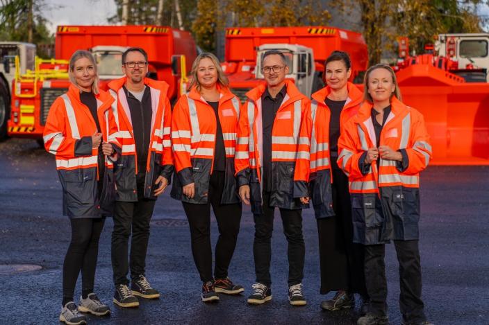 Sandvikin työntekijöitä poseeraamassa kameralle työkoneiden edessä. (Kuva: Sandvik)