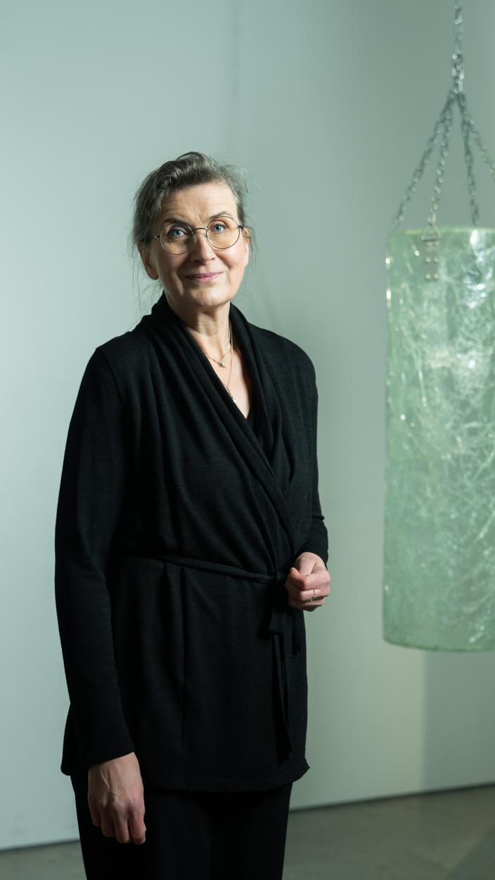 Suoraan kameraan katsova nainen, taustalla nyrkkeilysäkin muotoinen taideteos. (Kuva: Jussi Virkkumaa)