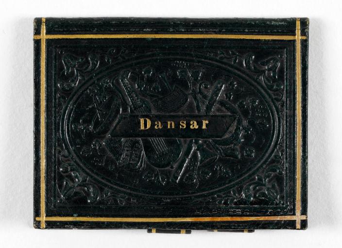 Mustakantinen pieni vihko, jonka kannessa kohopainolla tanssiva pariskunta sekä teksti "Dansar". (Kuva: Anna Saarikko, Turun kaupunginmuseo)