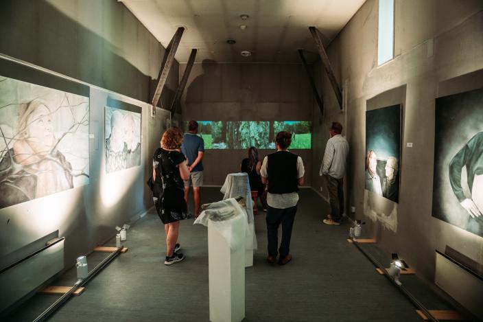 Ihmisiä katsomassa näyttelyn teoksia. (Kuva: Jussi Virkkumaa)