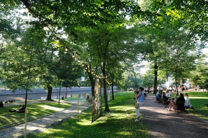 Ihmisiä viettämässä kesäiltaa vihreässä puistossa. (Kuva: Pasi Leino)