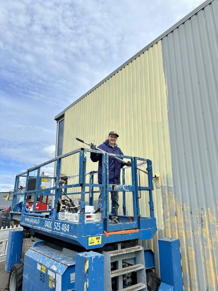 Taiteilija maalaamassa muraalia nostolavalta käsin. (Kuva: SAV Taidekollektiivi)