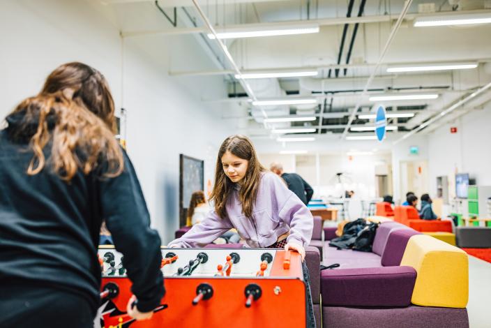 Kaksi nuorta pelaavat pöytäfutista nuorisotilalla.