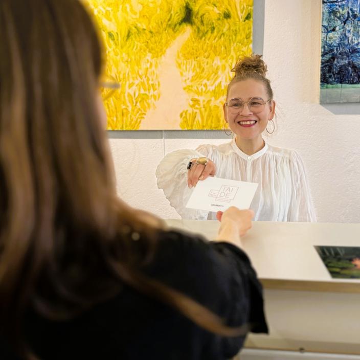 Turun taidelainaamon työntekijä palvelemassa asiakasta. (Kuva: Turun Taiteilijaseura)