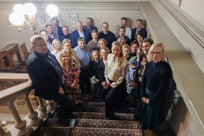 Työllisyysalueen neuvottelukunnan jäsenet seisovat portaissa ja katsovat hymyillen kameraan. (Kuva: Tarja Tötterman)