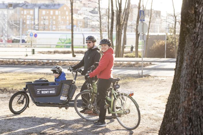 Perhe pyöräilemässä. Lapsi matkustaa tavarapyörän kyydissä. (Kuva: Suvi Elo)