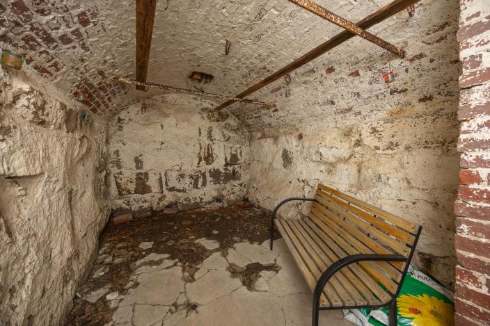 Vanha, tyhjä perunakellari, jossa on yksi penkki. (Kuva: Mika Okko)