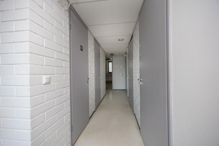 Käytävä, jonka varrella useita ovia. (Kuva: Mika Okko)