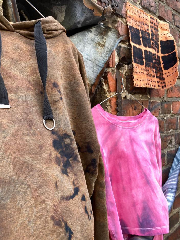 Batiikkivärjättyjä vaatteita ja tekstiilejä kuivumassa tiiliseinällä. (Picture: Maria Marquis)