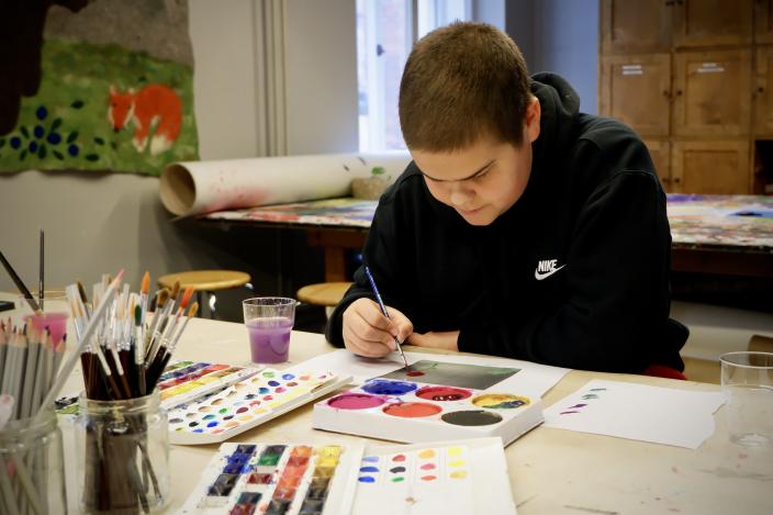 Nuori maalaamassa vesiväreillä Vimman taidepajassa. (Kuva: Niina Vääräniemi)