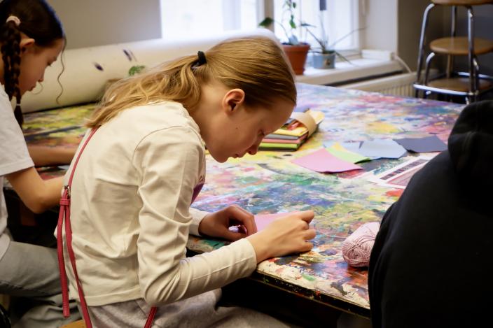 Kaksi nuorta Vimman taidepajan pöydän ääressä tekemässä kirjontaa keskittyneesti. (Kuva: Niina Vääräniemi)