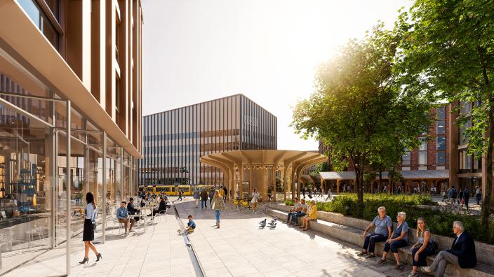 Ihmisiä vehreällä, talojen reunustamalla aukiolla. Taustalla Taito-kampus. (Kuva: Turun kaupunki, Lundén Architecture Company, Renell Käppi Arkkitehdit &amp; Cobe)