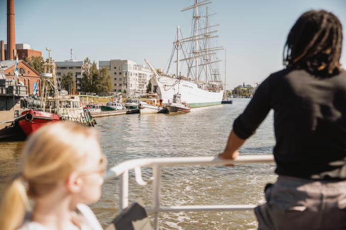 Kaksi ihmistä katselee Aurajoki-maisemaa Ruissalon vesibussin kyydissä. (Kuva: Visit Turku Archipelago)