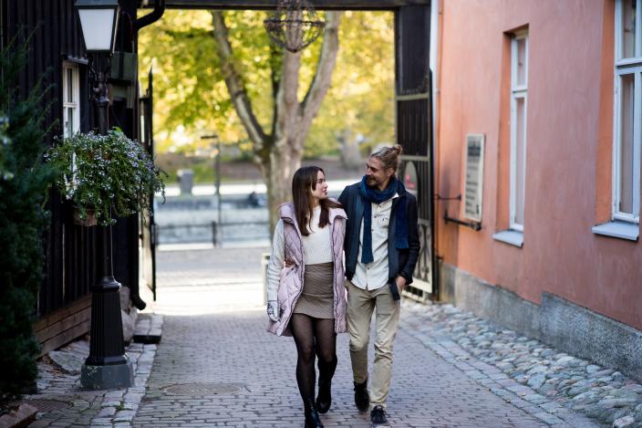 Nuori pariskunta kävelyllä Turun kaupungilla jokirannassa.