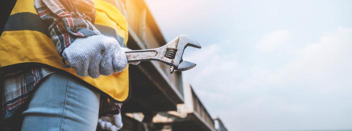 Kuva työmiehestä, joka pitää jakoavainta kädessä valmiina töihin. (Kuva: Adobe Stock/The Evening)