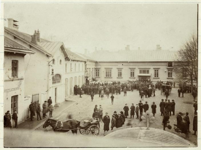 Vanha valokuva kaupungintalon ympäristössä, jossa osoitetaan mieltä suurlakon aikaan, etualalla hevonen vetää kärryä. (Kuva: Turun kaupunginmuseo)