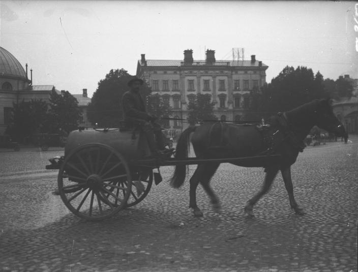 Hevosen vetämä säiliövaunu kauppatorilla pesemässä toria. (Kuva: Turun Sanomat / Turun kaupunginmuseo)