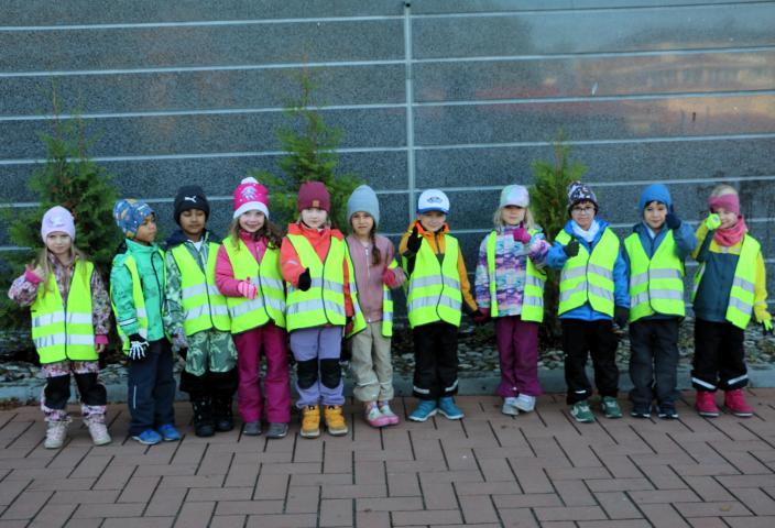 Förskolebarn i reflexvästar poserar i en grupp utanför. (Foto: Hannele Sivonen)